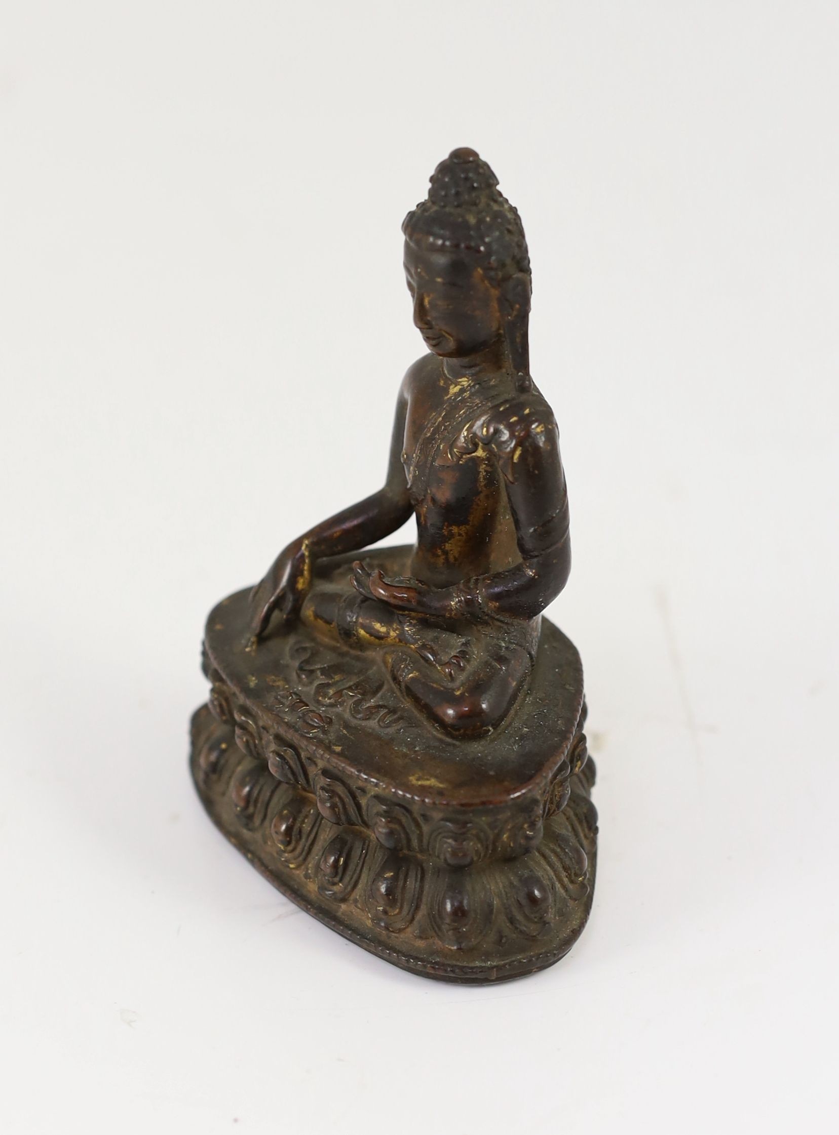 A small Tibetan gilt copper alloy seated figure of Buddha Shakyamuni, probably 15th/16th century, 10.4cm